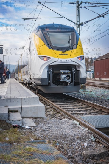 A modern SWEG train stops at the station. Blue-yellow accents contrast with the blue sky, battery electric train Siemens Micro Plus B, Hermann, Hesse, Bahn, Weil der Stadt, Böblingen district, Germany