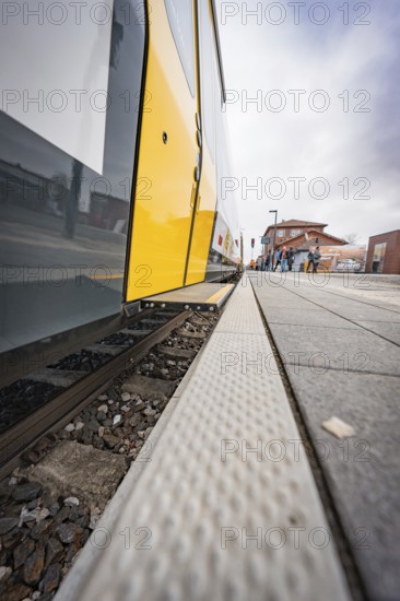 Close-up of a yellow train on a railroad track with focus on the rails, battery electric train Siemens Micro Plus B, Hermann, Hesse, Bahn, Weil der Stadt, Böblingen district, Germany