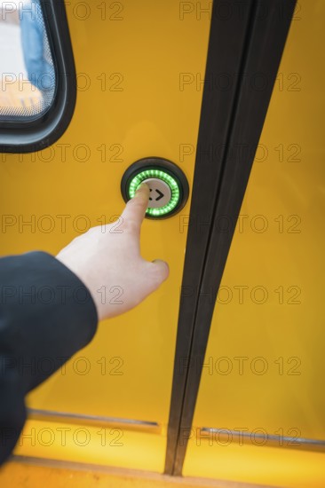 Close-up of a hand pressing a green door button on a yellow train, battery electric train Siemens Micro Plus B, Hermann, Hesse, Bahn, Weil der Stadt, Böblingen district, Germany
