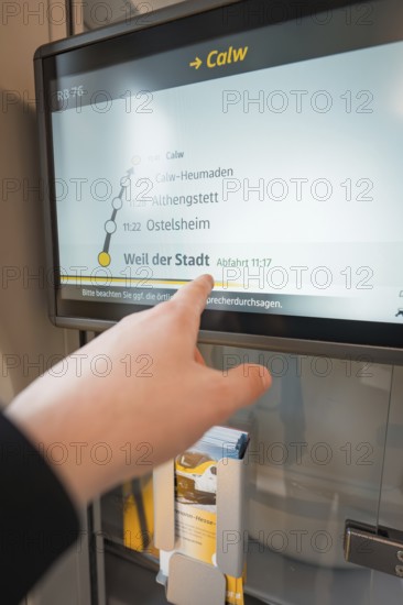 Hand points at a display with timetable and departure times on the train, battery electric train Siemens Micro Plus B, Hermann, Hesse, Bahn, Weil der Stadt, Böblingen district, Germany