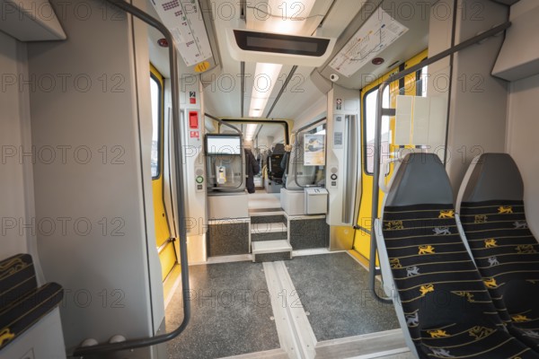 Interior of a modern train with grey and yellow elements and vacant seats, Siemens Micro Plus B battery electric train, Hermann, Hesse, Bahn, Weil der Stadt, Böblingen district, Germany