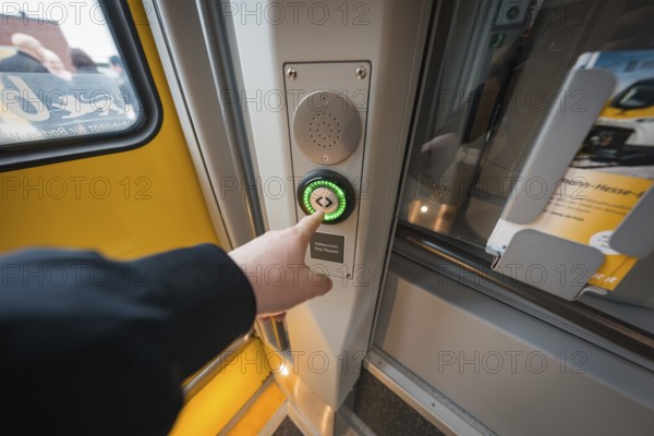 Hand presses the illuminated door button on the yellow train door, battery electric train Siemens Micro Plus B, Hermann, Hesse, Bahn, Weil der Stadt, Böblingen district, Germany