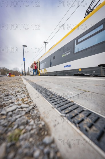 Person walking next to a modern yellow train on the platform, Siemens Micro Plus B battery electric train, Hermann, Hesse, Bahn, Weil der Stadt, Böblingen district, Germany