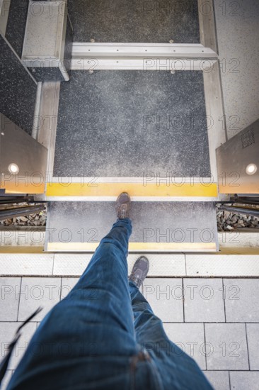 View from above of a passenger crossing the platform. A dynamic perspective with concrete paving, Siemens Micro Plus B electric train battery, Hermann, Hesse, Bahn, Weil der Stadt, Böblingen district, Germany