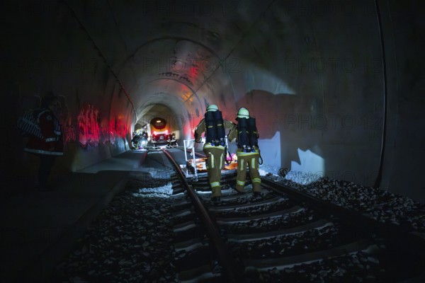 Firefighters walk through a tunnel in a dark, glowing atmosphere, fire drill at the Hermann-Hesse Railway, Ostelsheim, Germany