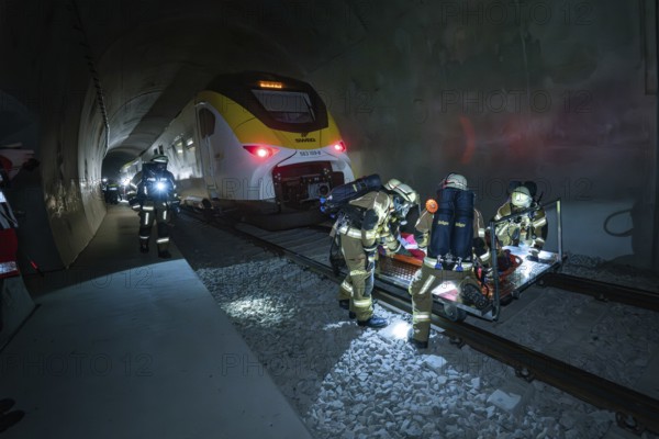 Firefighters work in a tunnel next to a train on a rescue operation, fire drill on the Hermann-Hesse railway, Ostelsheim, Germany