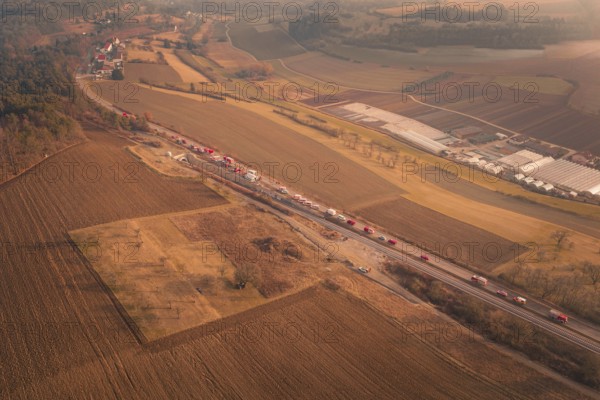 Aerial view of emergency vehicles on country road with visible tunnel and extensive fields at dusk, fire drill on the Hermann-Hesse railway, Ostelsheim, Germany
