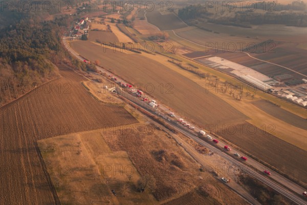 Fire trucks on a country road with a view of surrounding fields and village at dusk, fire drill on the Hermann Hesse Railway, Ostelsheim, Germany
