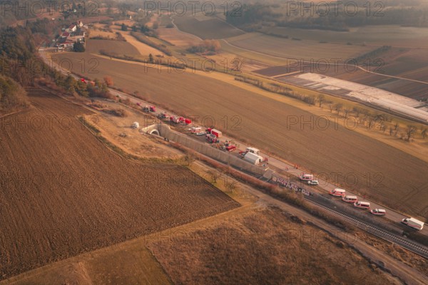 Aerial view of fire engines on a country road with tunnel and surrounding fields, fire drill on the Hermann-Hesse railway, Ostelsheim, Germany