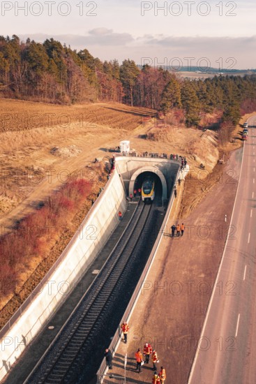 Train is just entering a railway tunnel surrounded by landscape and trees in aerial view, fire drill at the Hermann Hesse Railway, Ostelsheim, Germany