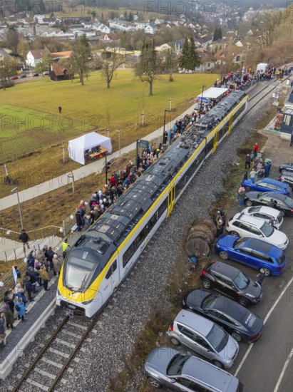 A train arrives in a village, people and parked cars along the tracks, opening of the Hermann Hesse Railway, Calw, Germany