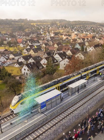 Train stops at a train station in a small town with many spectators and houses in the background, opening of the Hermann Hesse Railway, Calw, Germany