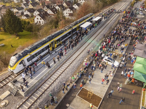 Large groups of people receive a train on the platform, surrounded by city and nature, opening of the Hermann Hesse Railway, Calw, Germany