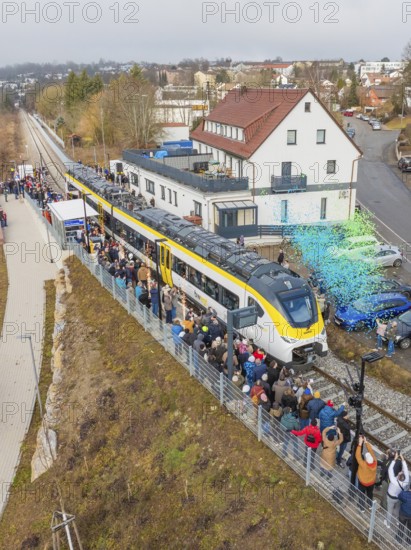 Regional train at a station event with crowds and rain of confetti in a city environment, opening of the Hermann Hesse Railway, Calw, Germany