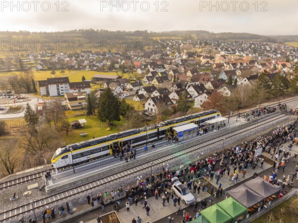 Train stops at a platform in a small town surrounded by people and houses, opening of the Hermann Hesse Railway, Calw, Germany