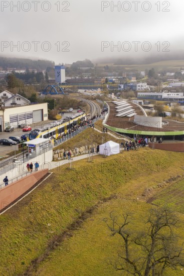 A large crowd gathers at a station area in a hilly landscape, opening of the Hermann Hesse Railway, Calw, Germany