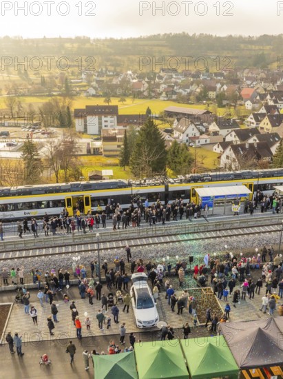 A train with people waiting on a platform in rural surroundings, opening of the Hermann Hesse Railway, Calw, Germany