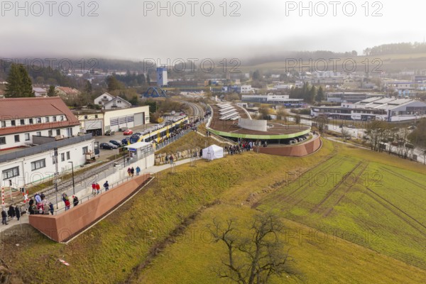 Station from above with surrounding urban landscape and people, drafty morning sky, opening of the Hermann Hesse Railway, Calw, Germany