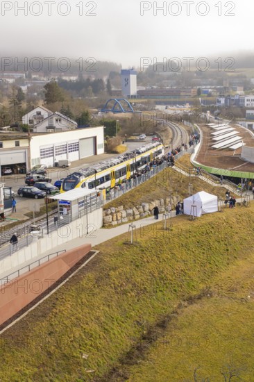 Landscape view with train and people along a railway line in an urban environment, opening of the Hermann Hesse Railway, Calw, Germany