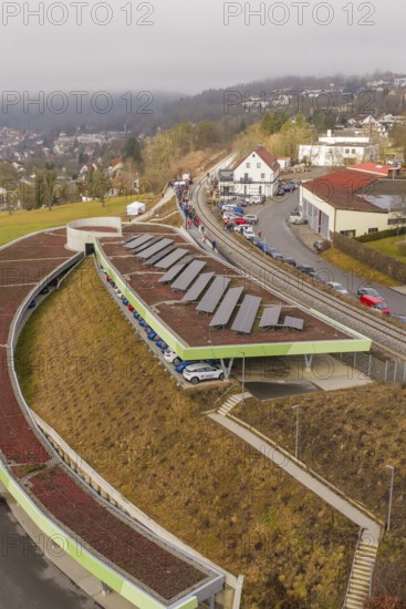 Solar panels on a hill in an urban landscape with cars and houses, opening of the Hermann Hesse Railway, Calw, Germany