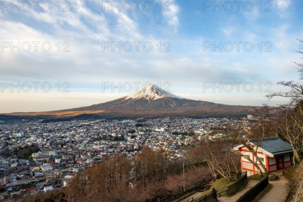 View of Mount Fuji volcano over Fujiyoshida City in morning light, at sunrise, Arakurayama Sengen Park, Yamanashi Prefecture, Japan