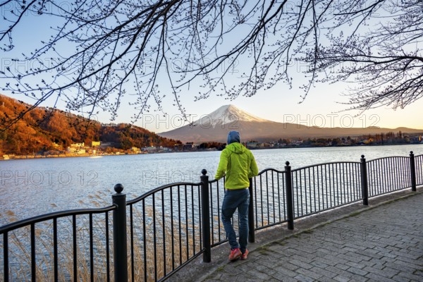 Tourist on Kawaguchi Lake waterfront, view of Mount Fuji volcano at sunset, Yamanashi Prefecture, Japan