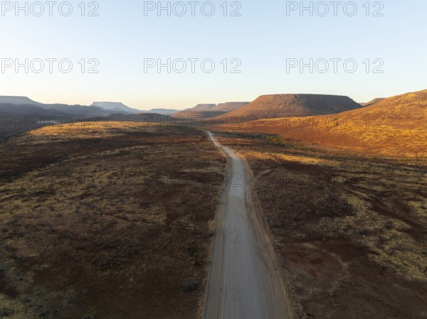 Aerial view, infinite space, straight road leads through dry desert landscape, hills in Damaraland, Namibia