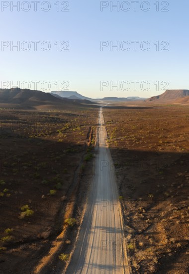 Aerial view, infinite space, straight road leads through dry desert landscape, hills in Damaraland, Namibia
