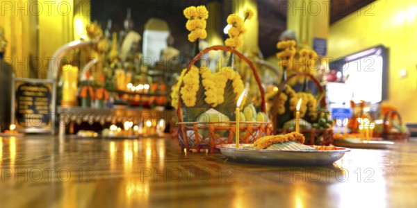 Sacrifices with candles, in front of numerous Buddhas and the City Pillar, which is considered the home of the city's protective spirit, Wat Si Muang temple complex, Vientiane, Laos