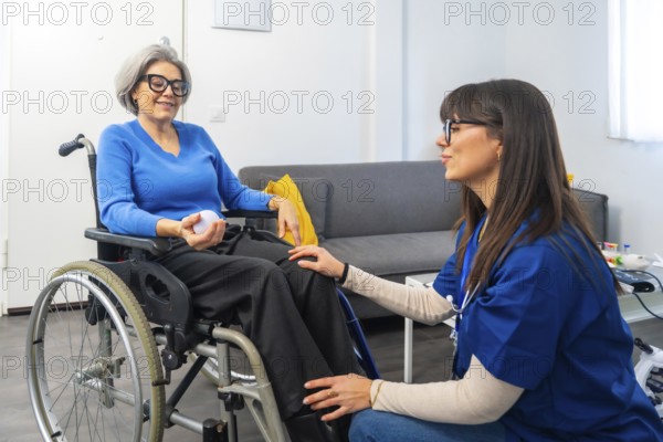 Young female caregiver chatting and smiling with an elderly woman in a wheelchair, offering support, companionship and gentle assistance in a bright indoor assisted living setting