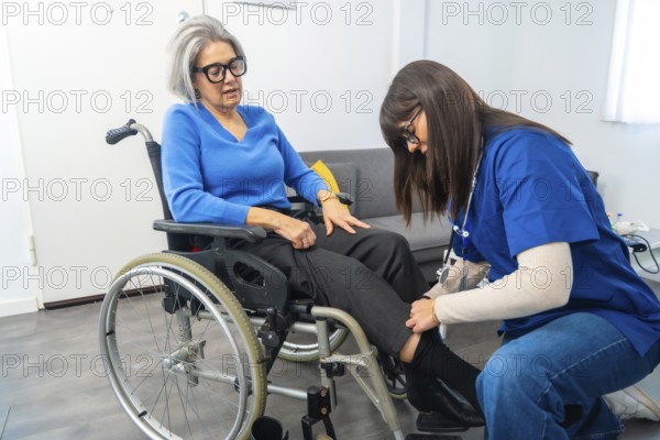 Care professional assisting an elderly woman in a wheelchair with her clothing, preparing for an activity or walk, highlighting themes of senior care, mobility, and support