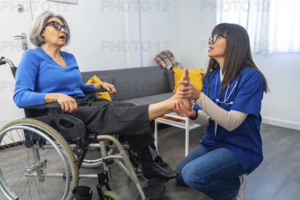 Medical professional performing a foot massage and rehabilitation exercises on an elderly patient in a wheelchair, providing care in a nursing home or hospital setting