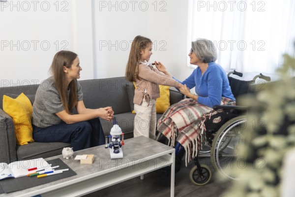Multi generational women at home, granddaughter holding grandmothers hands while an adult daughter watches, showing family love, support and intergenerational connection