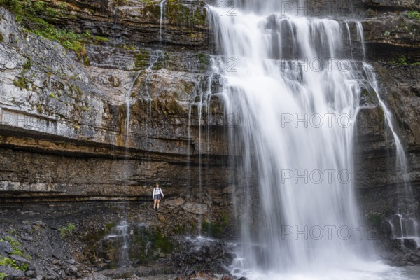 Little hiker in front of large Cascata di Mezzo waterfall, long exposure, Vallesinella, Brenta, Trentino, Italy