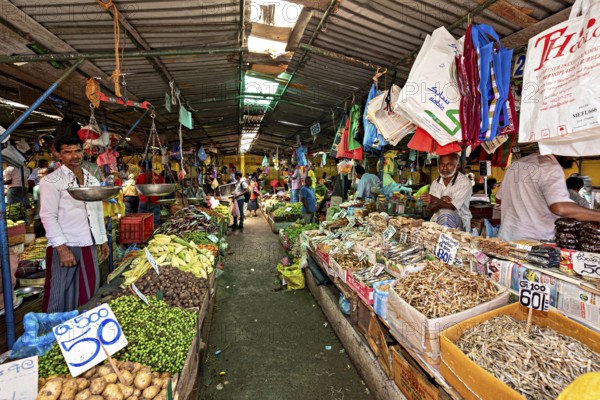 A busy market with various vegetable offerings and countless hanging rooms, The old market halls of Kandy in Sri Lanka