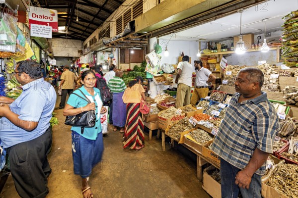 Lively marketplace with people looking at herbs and local produce, The ancient market halls of Kandy in Sri Lanka