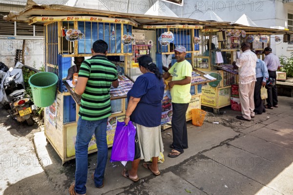 Small street shops with people buying newspapers and magazines, The old market halls of Kandy in Sri Lanka