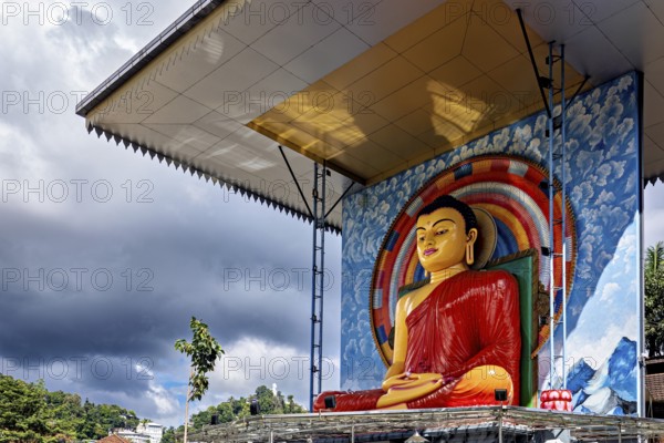 Large Buddha statue under a roof surrounded by rainbow and cloudy sky, Buddha statue in Kandy in Sri Lanka