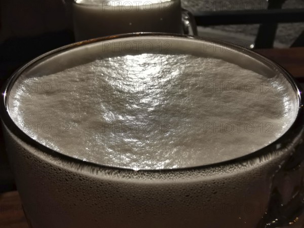 Close-up of a beer glass with creamy foam under evening light, Pilsen, Czech Republic