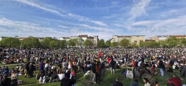 May 1, public holiday, Labor Day in Görlitzer Park in Berlin, many people sitting relaxing on the meadow under a blue sky, panorama, Berlin