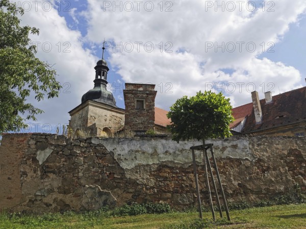 View of an old chapel behind a stone wall on a cloudy day, Czech Republic