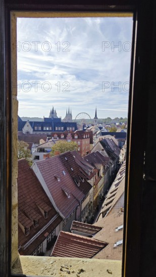 Through a window, a view of an urban landscape with roofs, church towers and a Ferris wheel, Erfurt, Thuringia