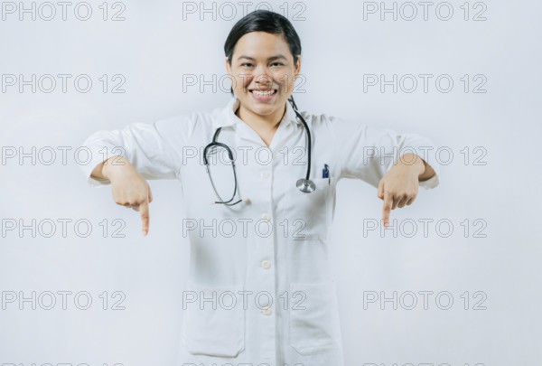 Young asian female doctor recommending an advertisement. Asian female doctor pointing at medical banner isolated