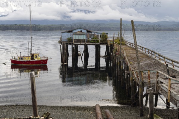 House on stilts with dock and boat on Pacific Ocean, Alert Bay, British Columbia