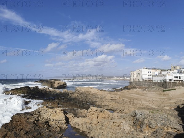 Rocky coast with buildings and clear sky in the distance, Essaouira, Morocco