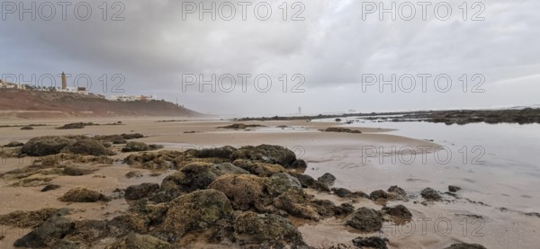 Rocky coast with calm sea under a cloudy sky, Morocco