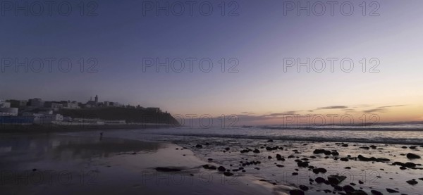 Sunset over a quiet beach, shimmering waves in evening light, Morocco