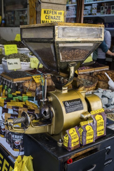 Antique coffee grinder next to spices and coffee on a busy market stall, Konya, Central Anatolia, Turkey