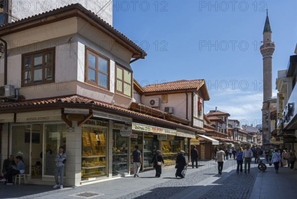 Bustling market street with traditional shops and a minaret in the background, Konya, Central Anatolia, Turkey