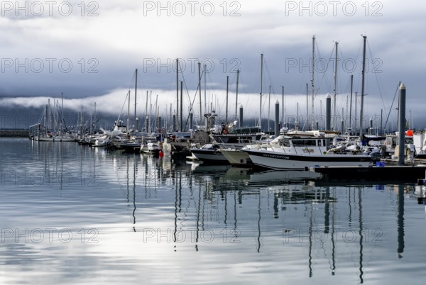 Boats in harbor, cloudy mountain peaks behind, with reflection, Seward, Kenai Peninsula, Alaska, USA